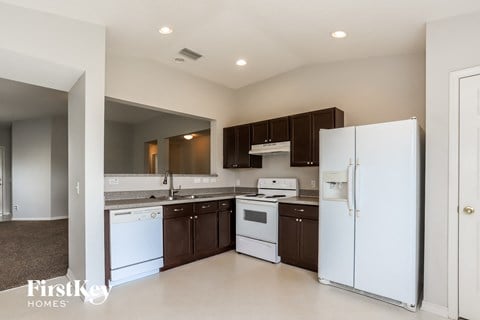 a kitchen with white appliances and brown cabinets and a white refrigerator