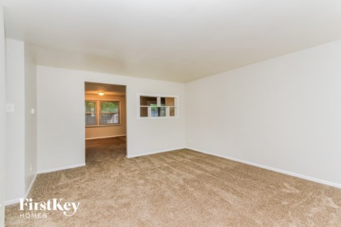 A room with a carpeted floor and a window.
