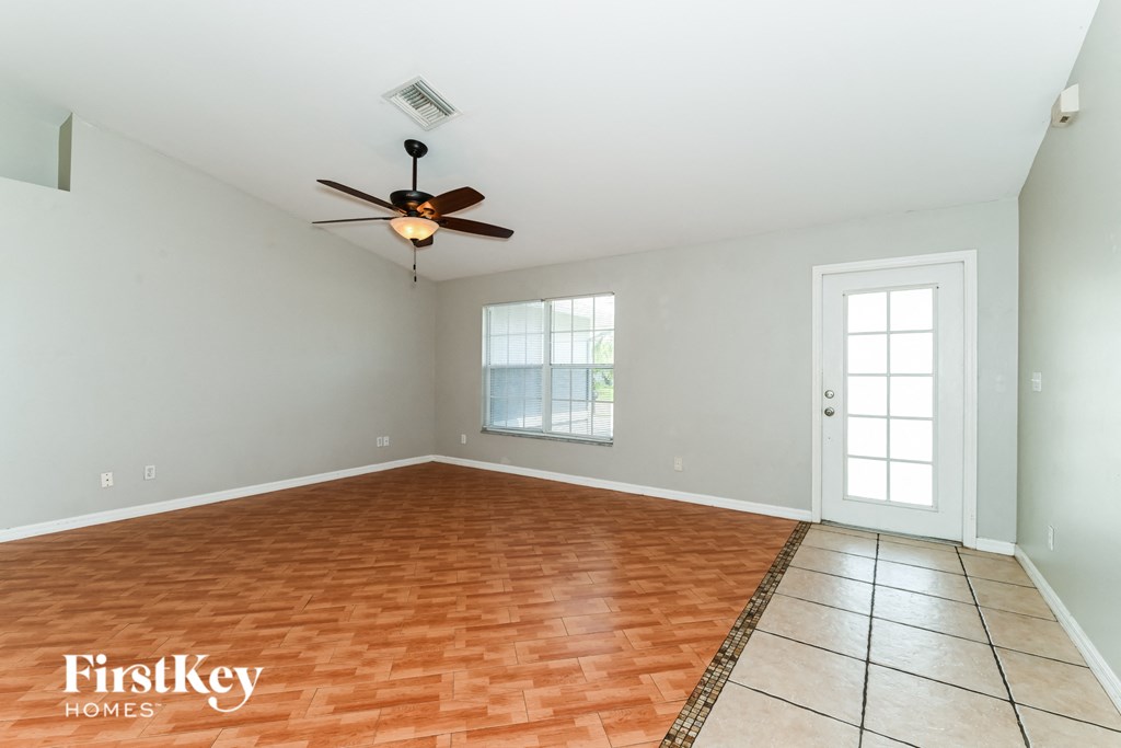 A room with a ceiling fan and tile flooring.