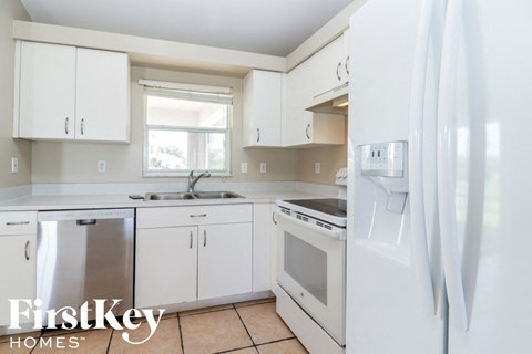 A kitchen with white cabinets and appliances.