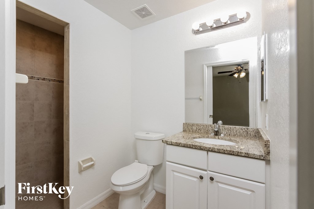 a bathroom with a sink toilet and a mirror