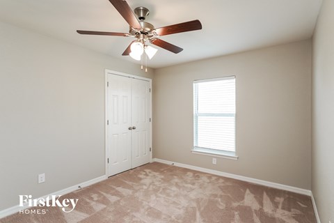 a bedroom with a ceiling fan and a closet