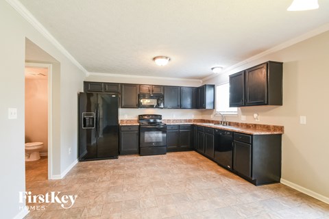 A kitchen with black appliances and cabinets.