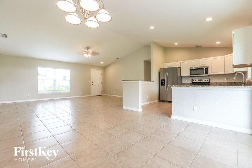 an open kitchen and living room with a large tile floor