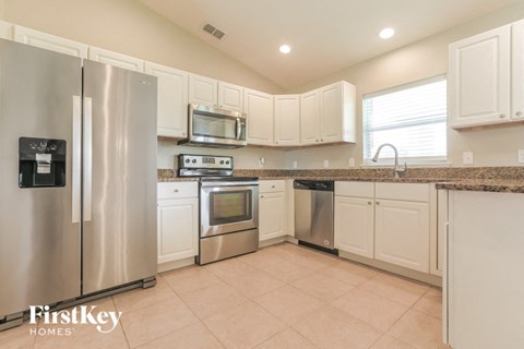 a kitchen with stainless steel appliances and white cabinets