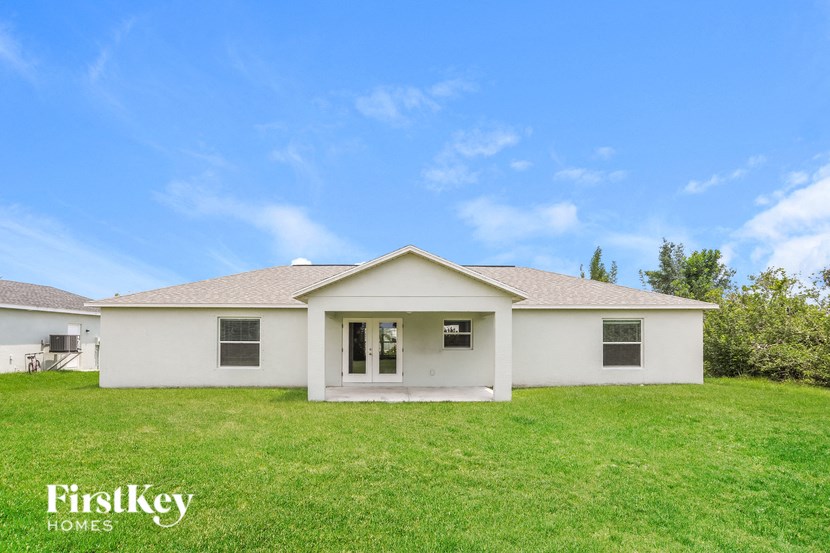 a white house with a green lawn and a blue sky