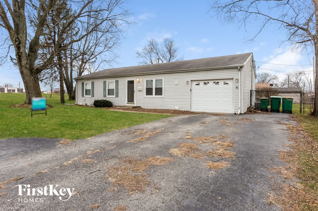 a small white house with a gravel road in front of it
