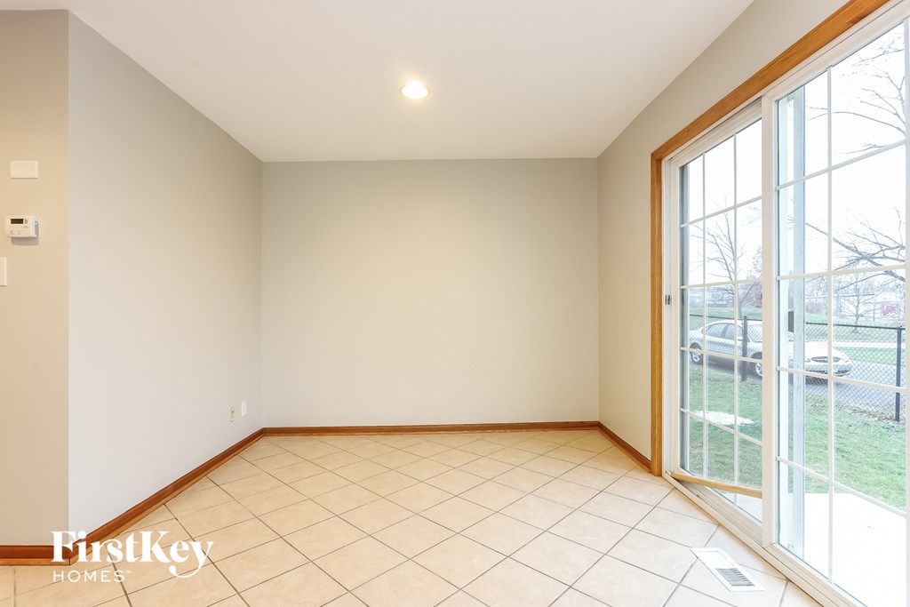 an empty living room with large windows and a tiled floor