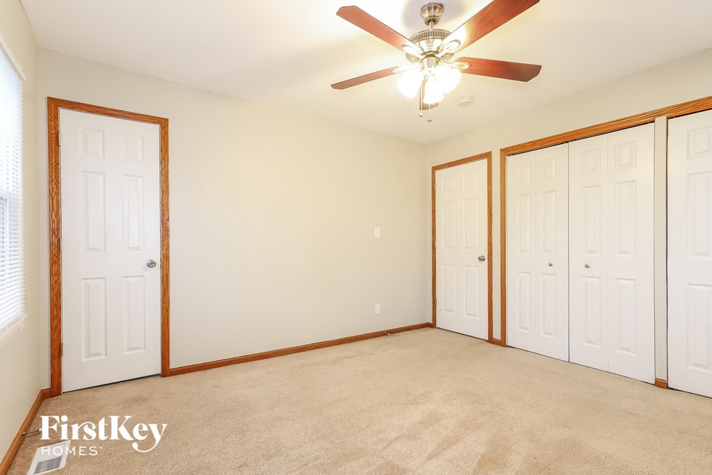 a bedroom with two closets and a ceiling fan