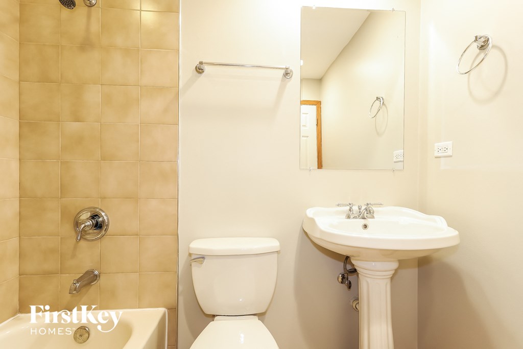 a bathroom with a toilet and a sink and a mirror