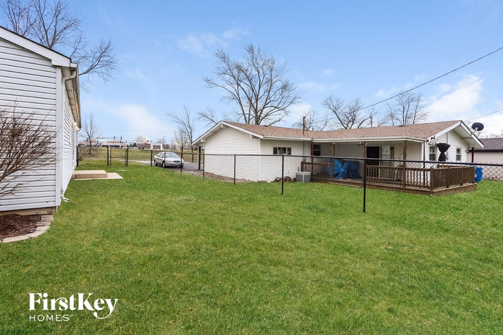 a house with a yard and a fence in front of it