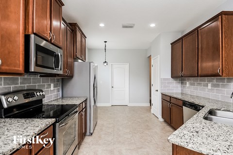 A kitchen with brown cabinets and a stove top oven.
