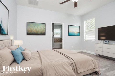 A bedroom with a large bed and a painting on the wall.