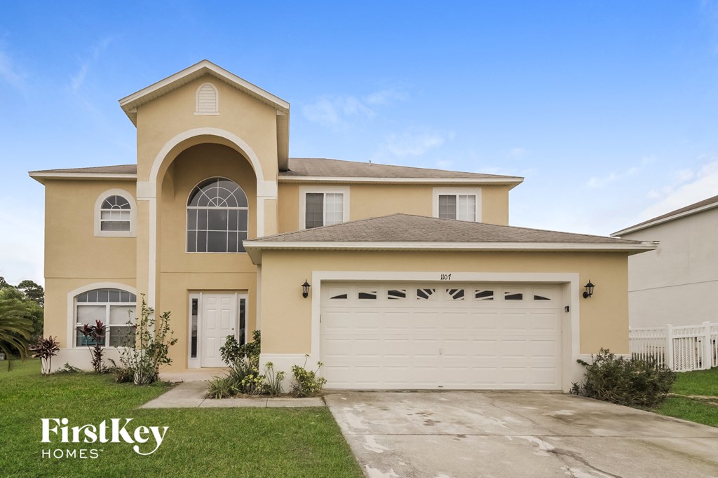 A large, two-story house with a garage is for sale.