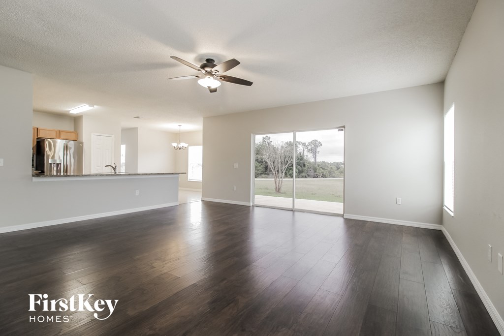 A spacious room with a ceiling fan and wooden flooring.