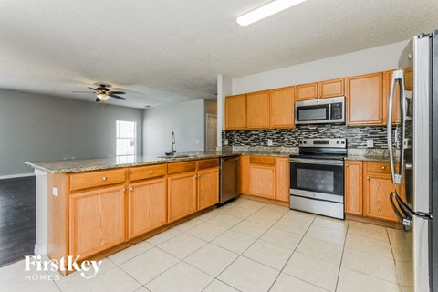 A kitchen with wooden cabinets and a tile backsplash.