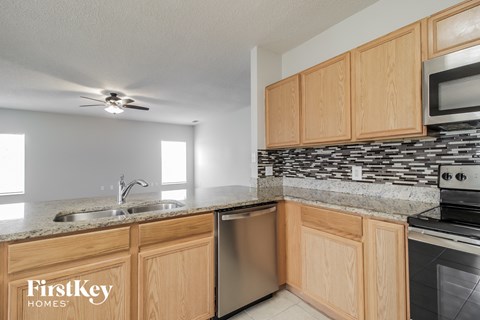 A kitchen with wooden cabinets and a stainless steel dishwasher.