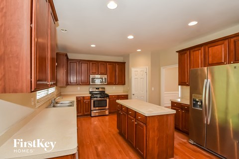 A kitchen with wooden cabinets and a stainless steel refrigerator.