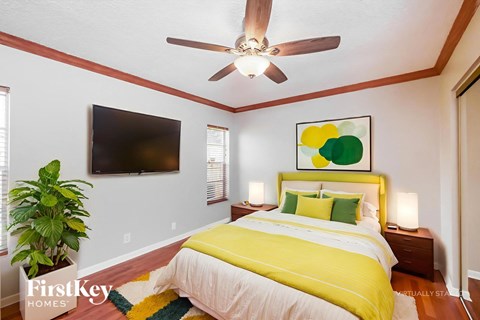A bedroom with a yellow bed and a ceiling fan.
