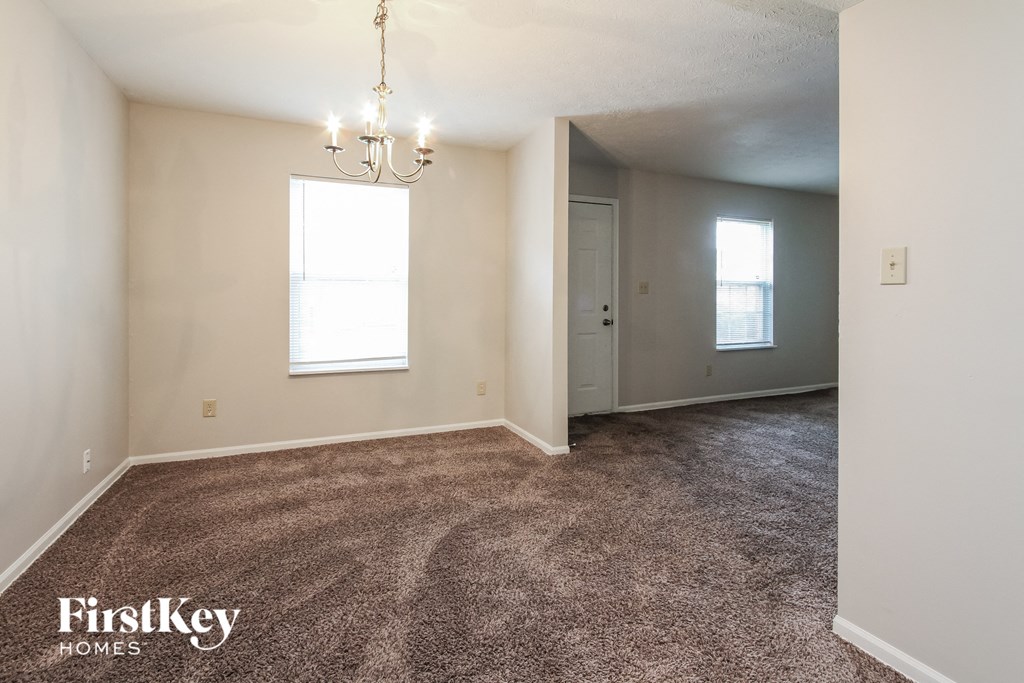 an empty living room with carpet and a window