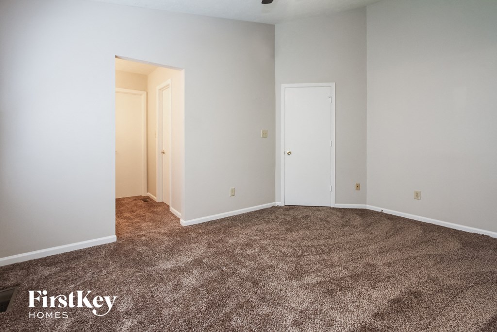 a bedroom with a carpeted floor and a door to a closet