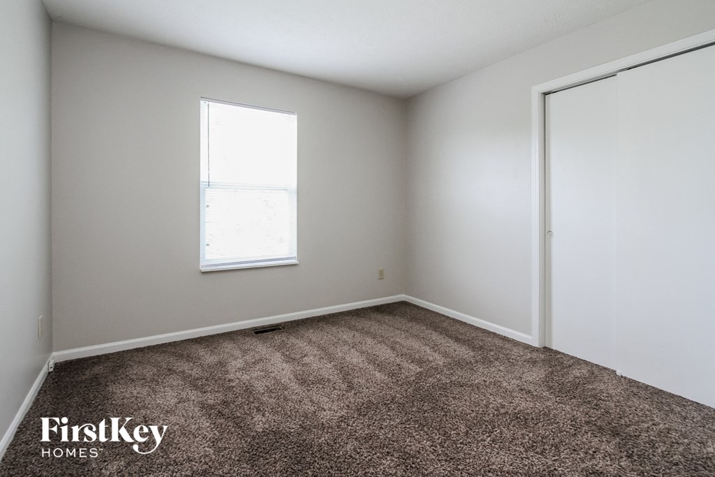 a bedroom with a carpeted floor and a window