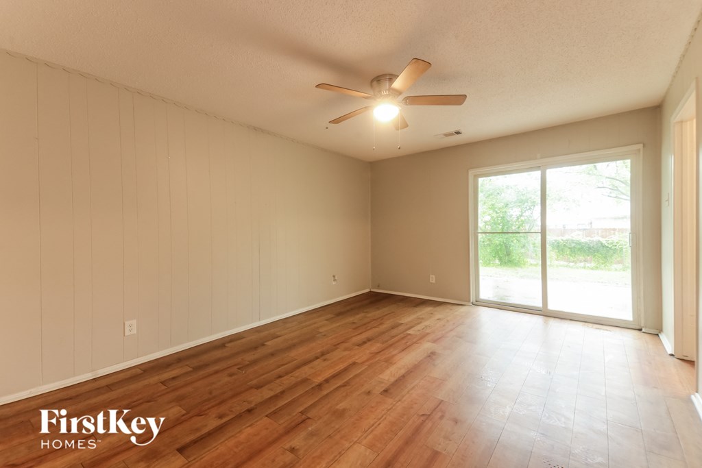 A room with wooden flooring and a ceiling fan.