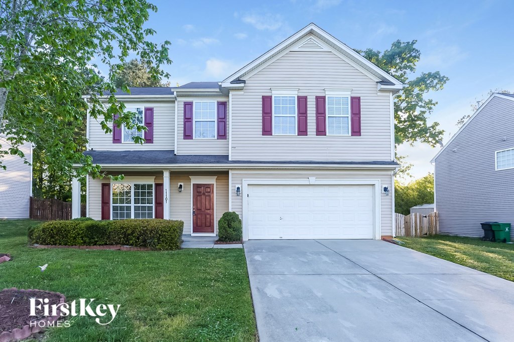 a white house with purple shutters and a driveway
