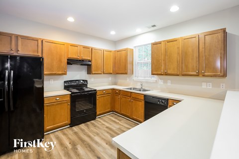 A kitchen with wooden cabinets and black appliances.