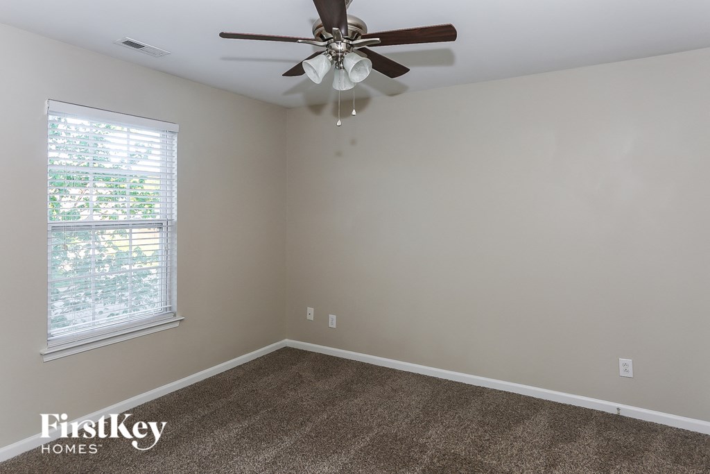 the living room of an empty house with a ceiling fan