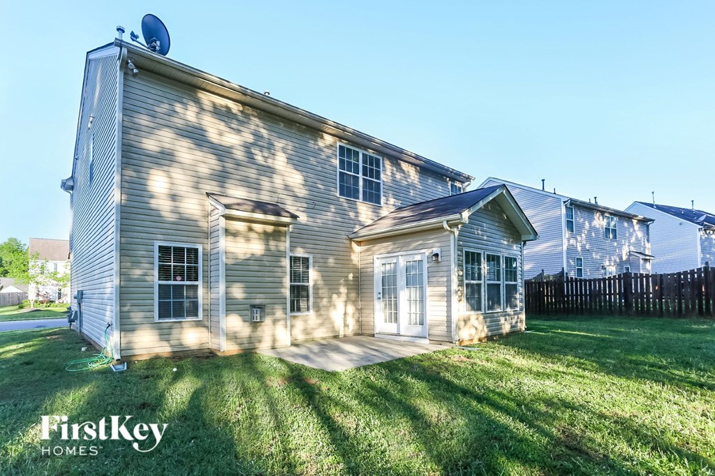 a side view of a house with a yard and a fence