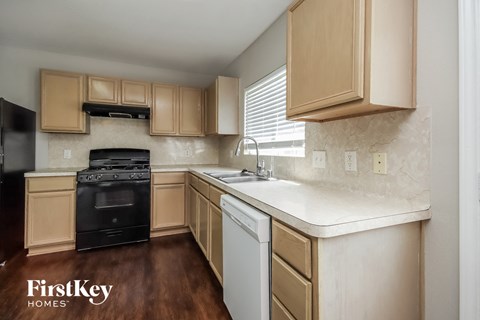 A kitchen with wooden cabinets and a black oven.