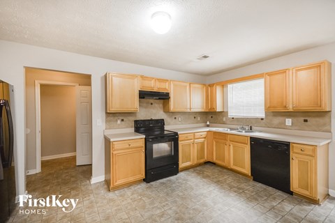 A kitchen with wooden cabinets and black appliances.