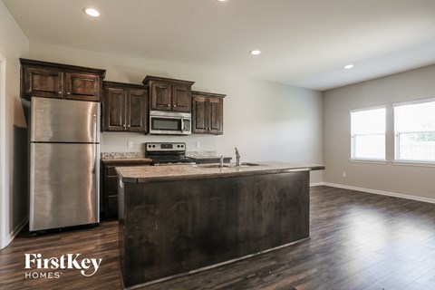 A kitchen with wooden cabinets and a stainless steel refrigerator.