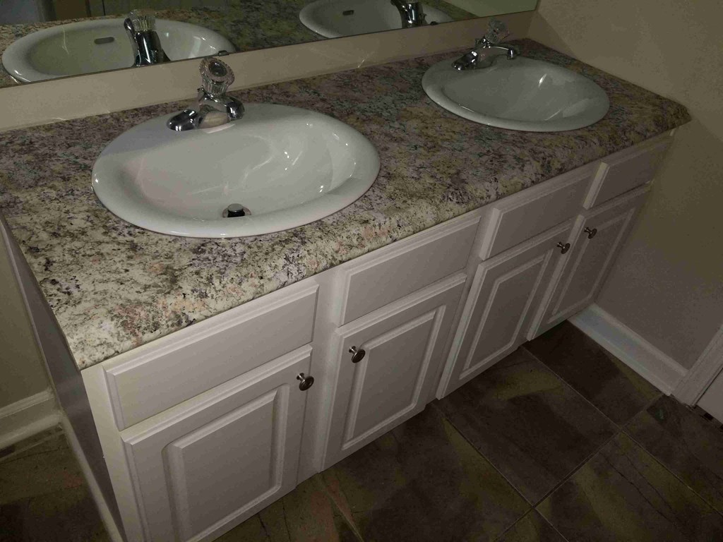 a bathroom with two sinks with granite counter tops