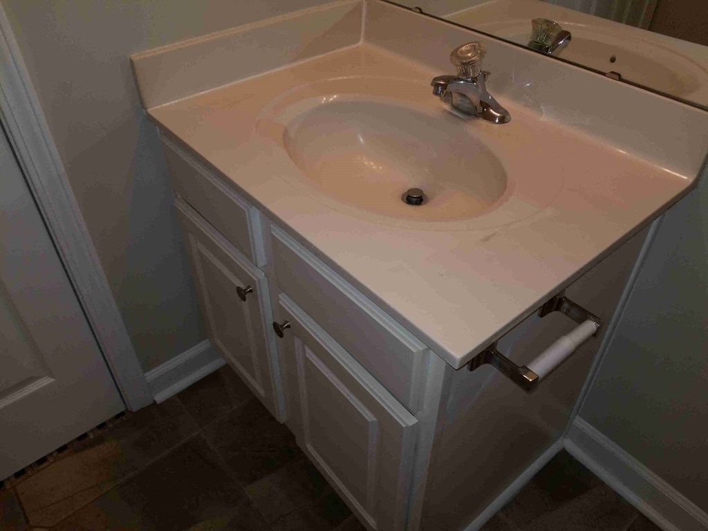a sink in a bathroom with a roll of toilet paper
