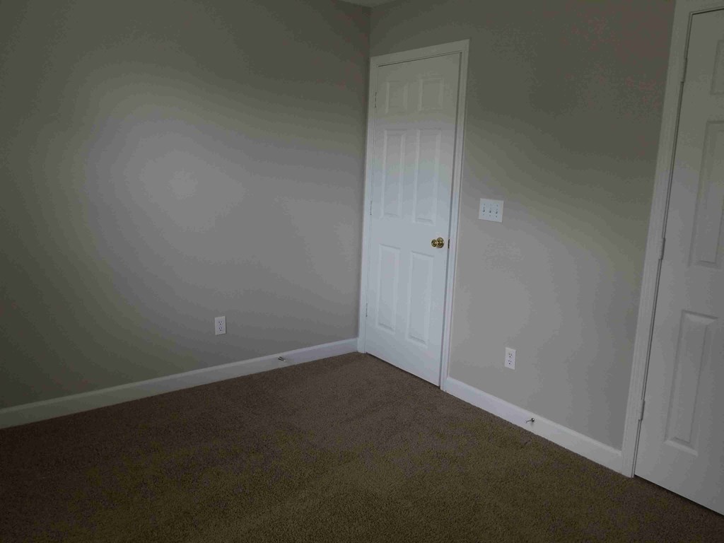 a room with a door and a carpeted floor