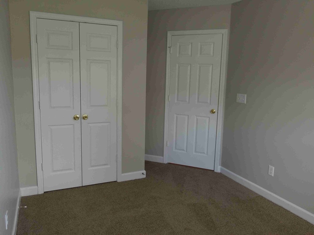 a room with two white doors and a carpeted floor