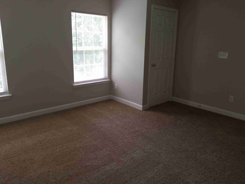 an empty room with a door and a window