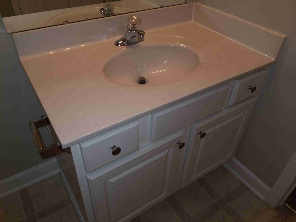 a sink in a bathroom with white cabinets