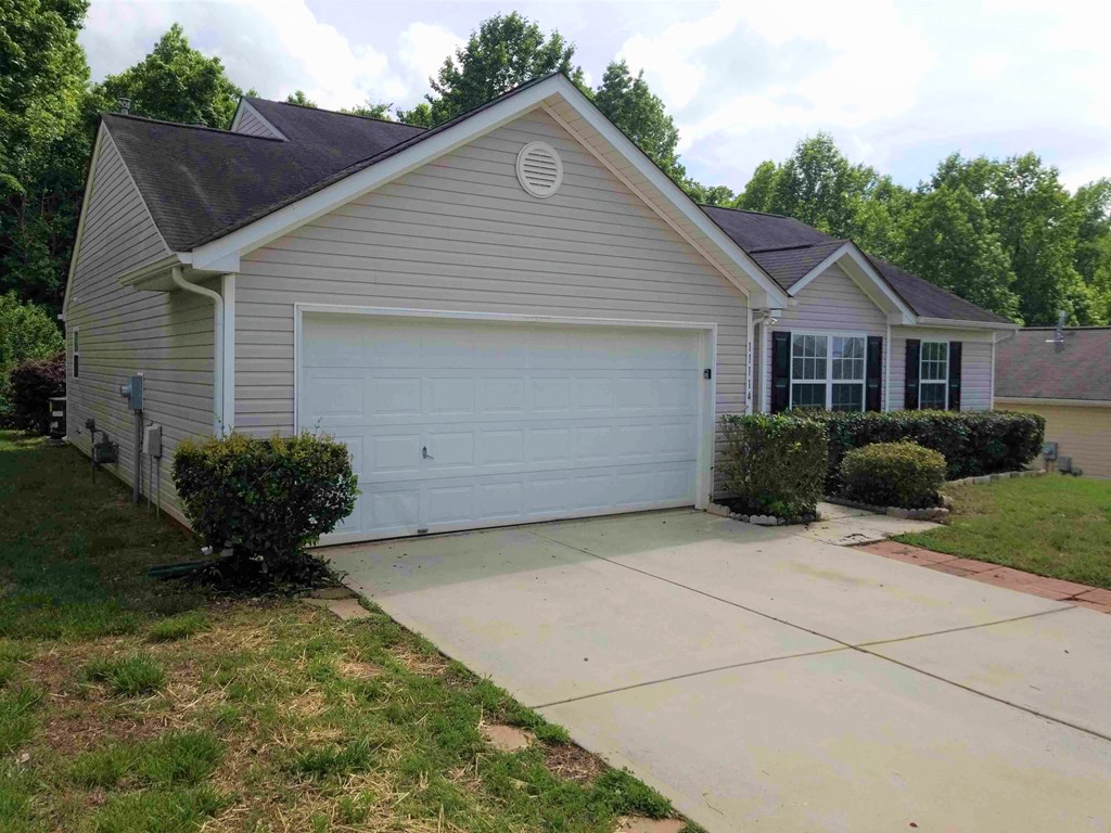 a home with a driveway and a white garage door