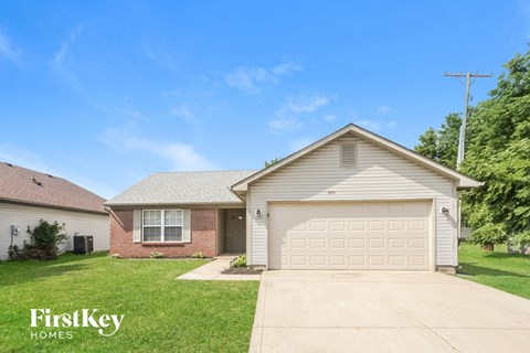 A house with a garage and a driveway in front of it.