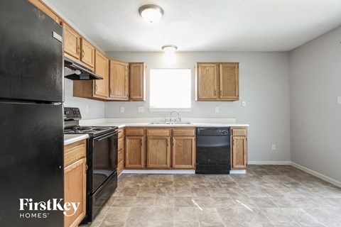 A kitchen with black appliances and wooden cabinets.