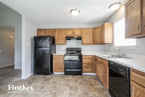 A kitchen with wooden cabinets and black appliances.