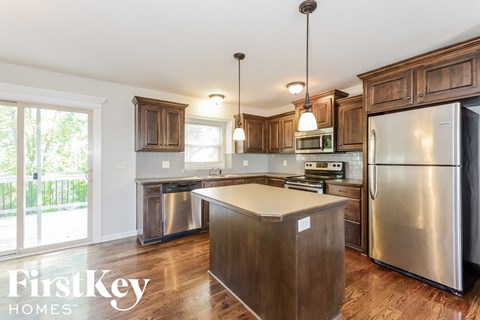 A kitchen with wooden cabinets and a stainless steel refrigerator.