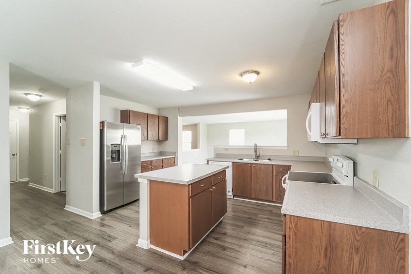 A kitchen with wooden cabinets and a white countertop.