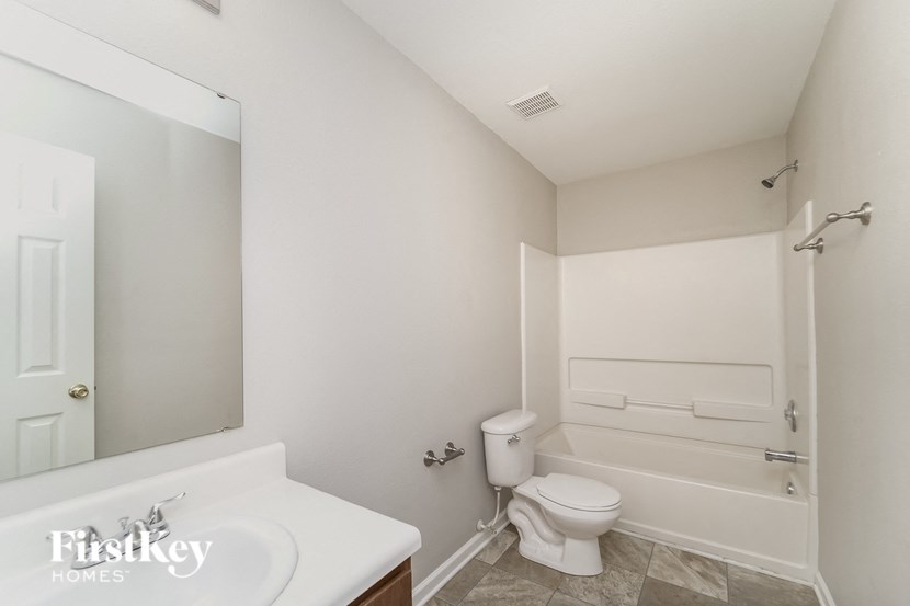 A white bathroom with a toilet, sink, and bathtub.