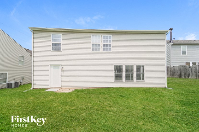 A two-story house with a white door and windows.