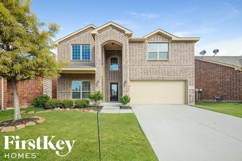 a brick house with a garage door and a driveway
