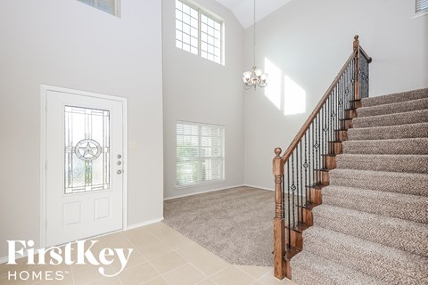 the entryway of a home with a staircase and a white door